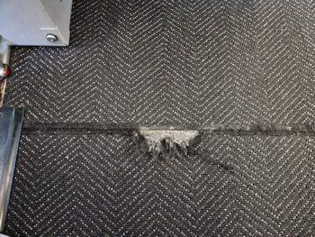 Torn Black Carpet Or Rug In Floor Of Airplane