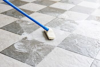 Cleaning The Tile Floor With A Long Handled Floor Brush.
